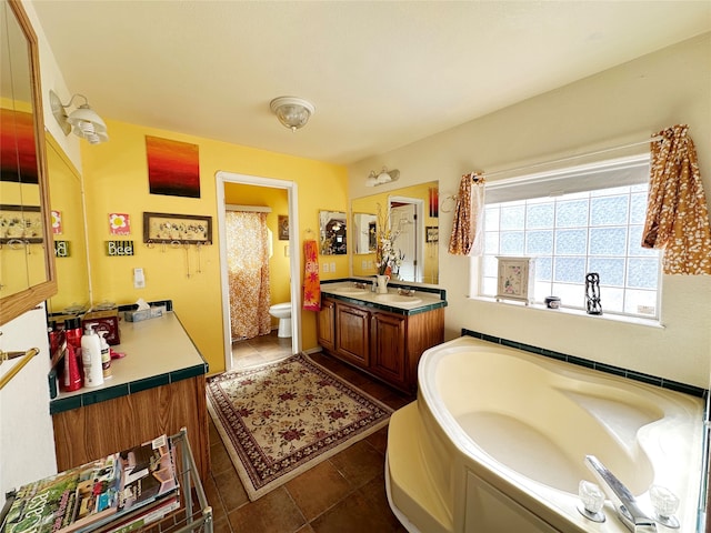 bathroom with tile patterned floors, vanity, a bath, and toilet