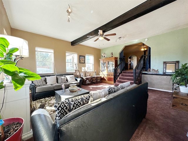 living room featuring beam ceiling, ceiling fan, and carpet