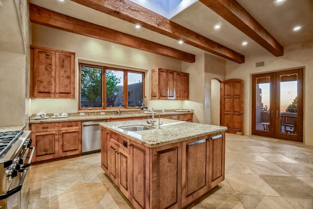 kitchen featuring appliances with stainless steel finishes, a center island with sink, light stone countertops, sink, and beam ceiling