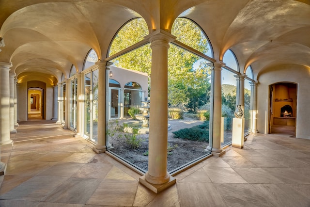 doorway to outside featuring decorative columns and light tile floors