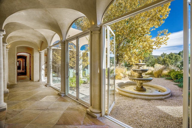 doorway with light tile flooring, decorative columns, and french doors