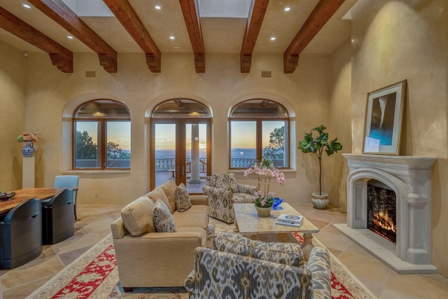 living room featuring a water view, light tile floors, and beamed ceiling