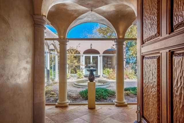 entryway with decorative columns and a wealth of natural light