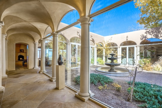 unfurnished sunroom featuring a healthy amount of sunlight and decorative columns