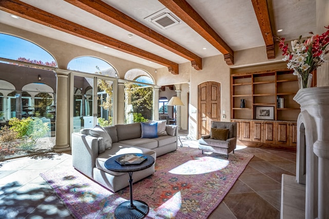 tiled living room with built in features, decorative columns, and beamed ceiling