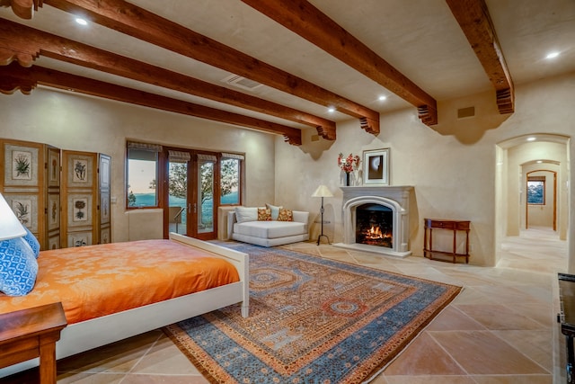 bedroom with french doors, beam ceiling, and light tile floors