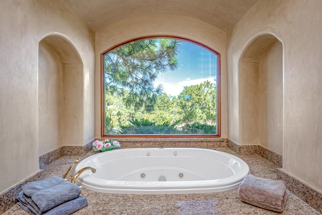 bathroom featuring lofted ceiling and a wealth of natural light