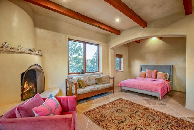 bedroom with light tile flooring and beam ceiling