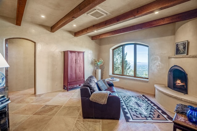 living area featuring beam ceiling and light tile flooring