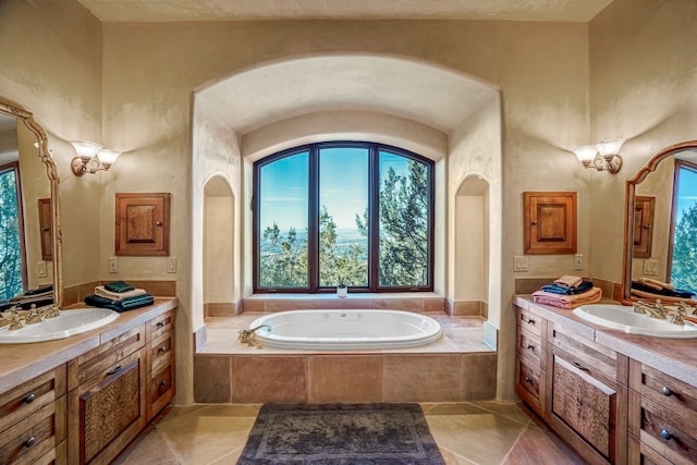 bathroom with a relaxing tiled bath, tile flooring, and dual bowl vanity