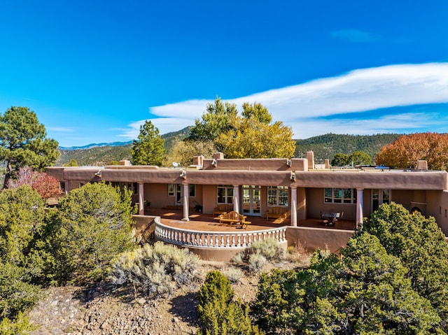 pueblo-style home with a mountain view and a patio