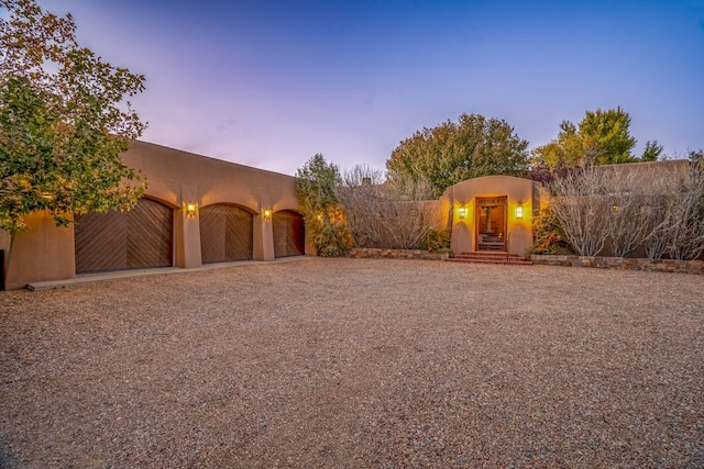 yard at dusk featuring a garage