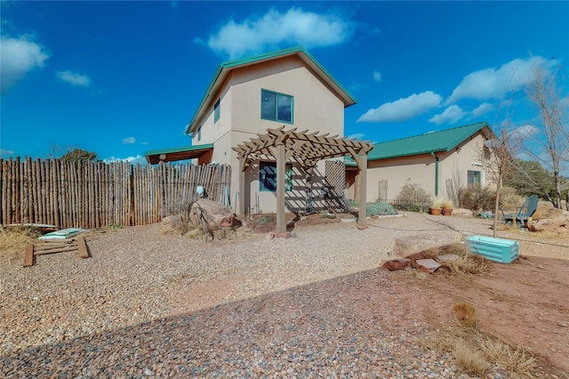 rear view of property with a pergola