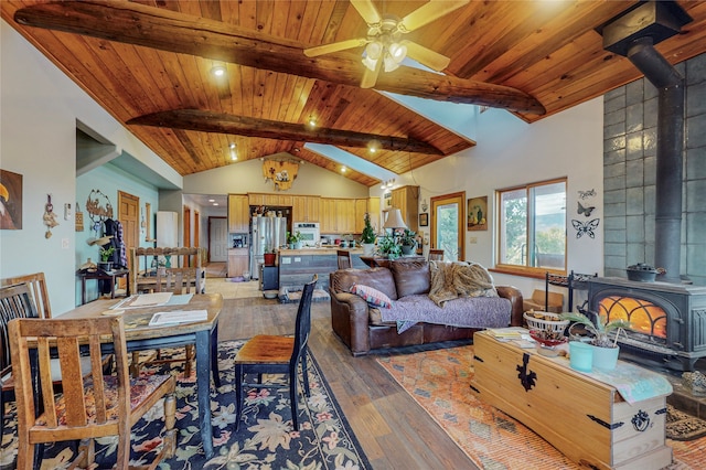 living room featuring beamed ceiling, wooden ceiling, hardwood / wood-style flooring, and a wood stove