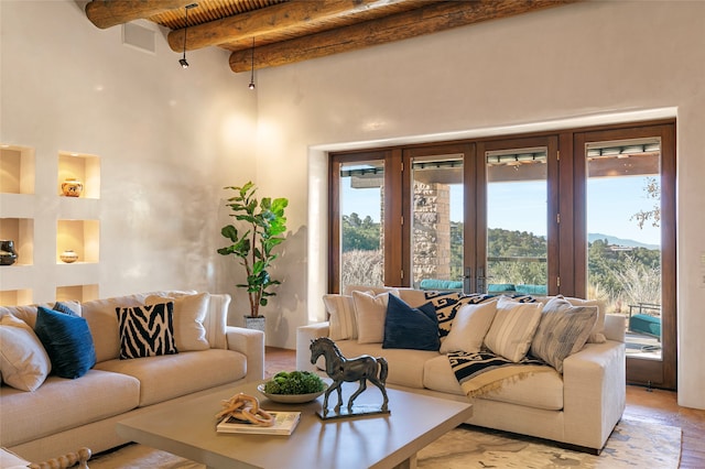 tiled living room with beamed ceiling, french doors, and a towering ceiling