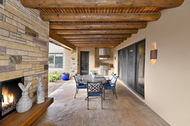 view of patio with grilling area and an outdoor stone fireplace