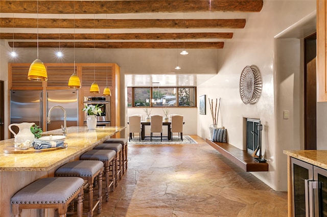 dining room with sink, beamed ceiling, and wine cooler