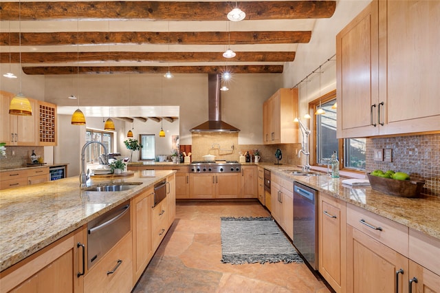 kitchen featuring wall chimney range hood, decorative backsplash, and plenty of natural light