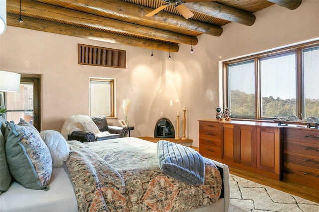 bedroom featuring beamed ceiling, multiple windows, hardwood / wood-style floors, and wood ceiling