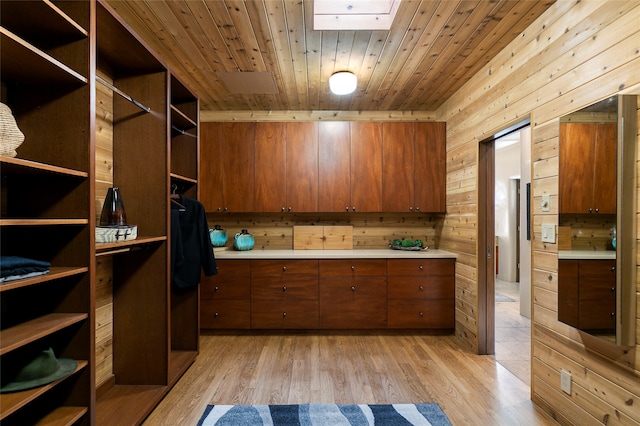 walk in closet with a skylight and light hardwood / wood-style floors