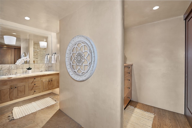 bathroom with tasteful backsplash, double sink vanity, and hardwood / wood-style floors