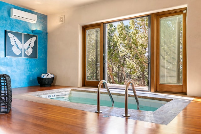 view of pool with an indoor hot tub and a wall mounted air conditioner