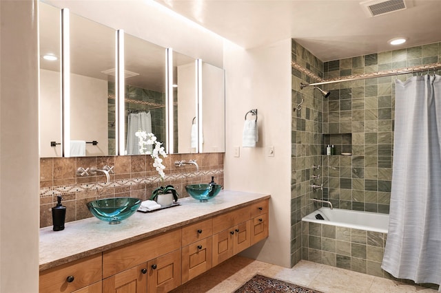 bathroom featuring double vanity, tile patterned flooring, tasteful backsplash, and shower / bath combo