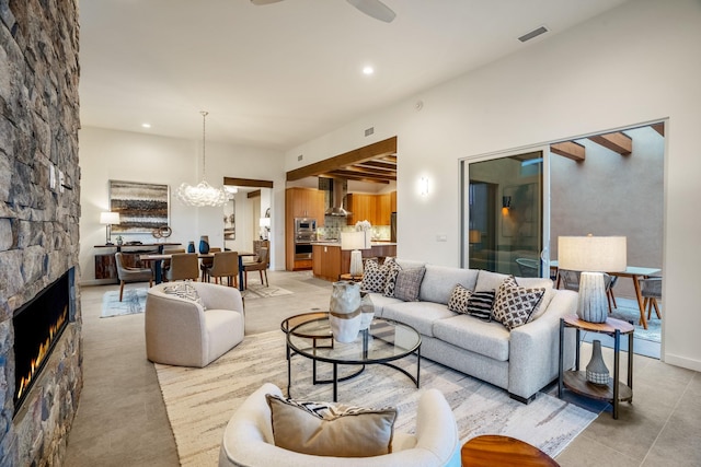 living room with a notable chandelier and a stone fireplace