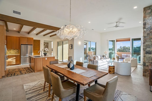 dining area featuring ceiling fan with notable chandelier, beam ceiling, and sink