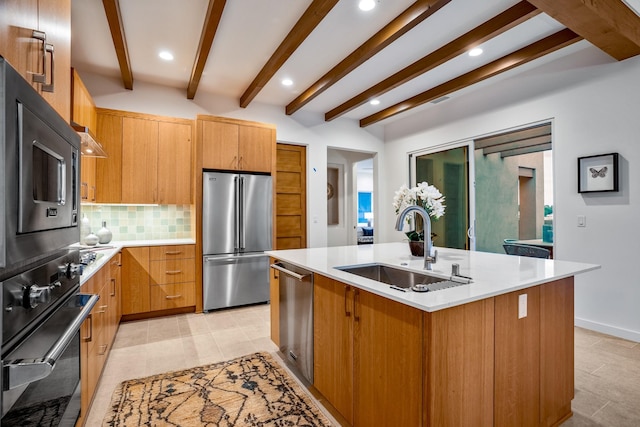 kitchen featuring a kitchen island with sink, appliances with stainless steel finishes, beam ceiling, sink, and backsplash