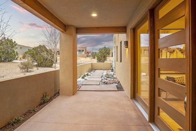 patio terrace at dusk featuring a balcony