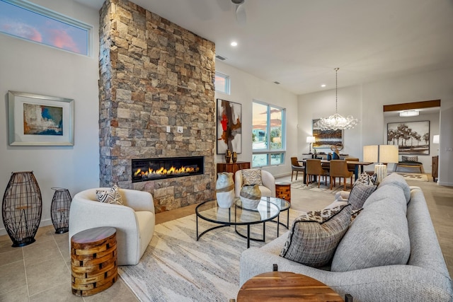 living room with a stone fireplace and an inviting chandelier