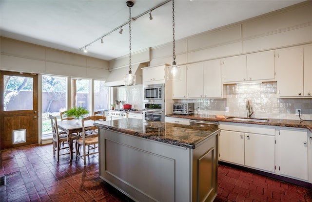 kitchen with stainless steel appliances, backsplash, and white cabinetry