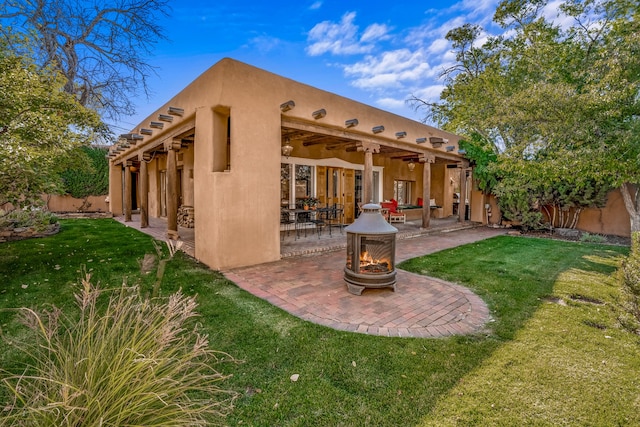 back of house featuring a yard, ceiling fan, and a patio