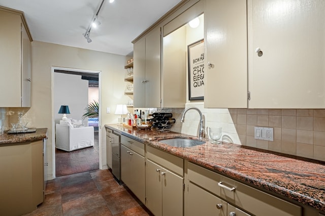 kitchen with dark tile floors, sink, rail lighting, dark stone countertops, and tasteful backsplash