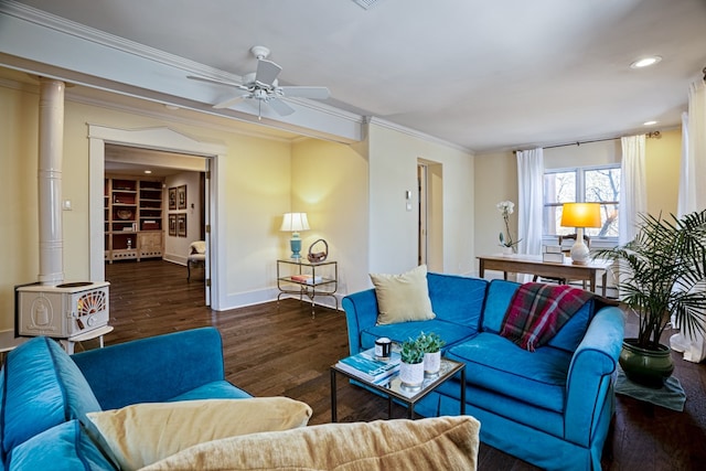 living room featuring dark wood-type flooring, a wood stove, ceiling fan, ornamental molding, and built in shelves