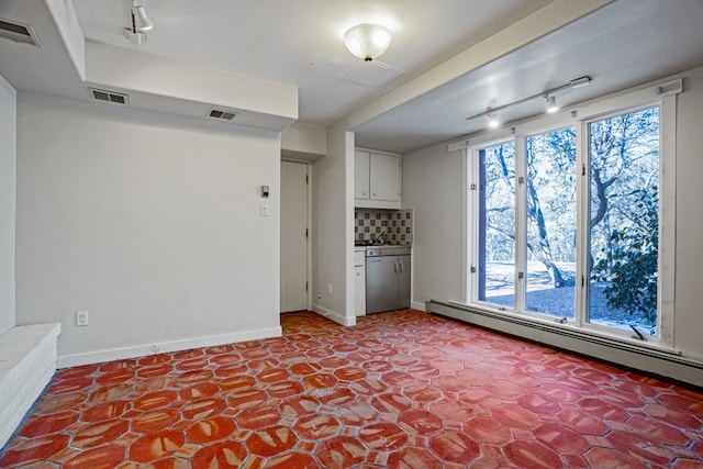 tiled spare room with baseboard heating and track lighting