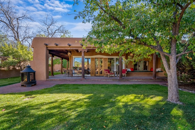 back of property featuring a yard, ceiling fan, and a patio