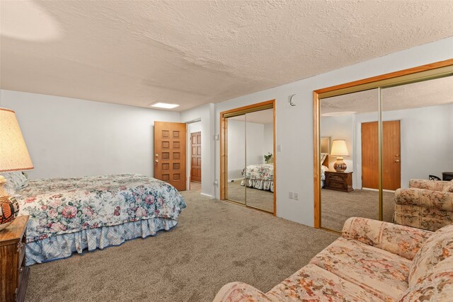 carpeted bedroom with two closets and a textured ceiling