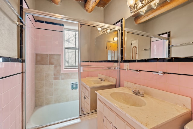 full bathroom featuring tile walls, tasteful backsplash, oversized vanity, and combined bath / shower with glass door