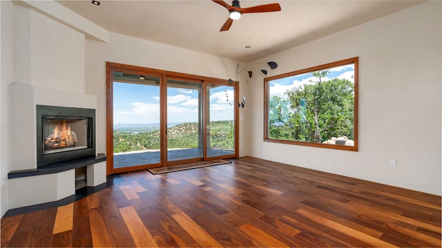 unfurnished living room featuring plenty of natural light, dark hardwood / wood-style floors, and ceiling fan