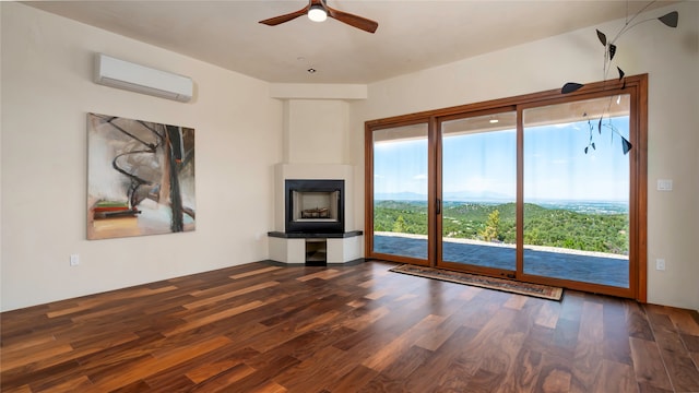 unfurnished living room with a large fireplace, dark hardwood / wood-style floors, ceiling fan, and a wall mounted air conditioner