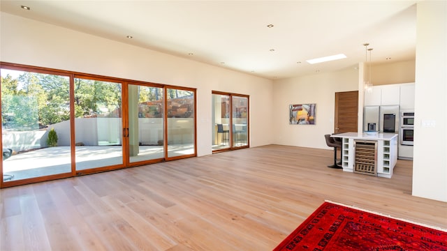 living room with beverage cooler and light hardwood / wood-style flooring