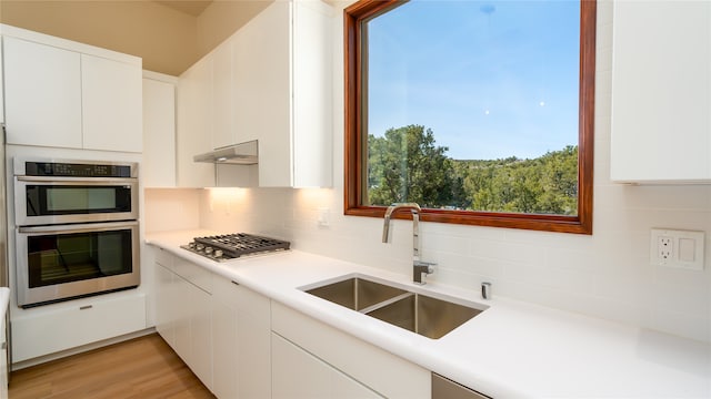 kitchen featuring white cabinets, appliances with stainless steel finishes, sink, and a wealth of natural light