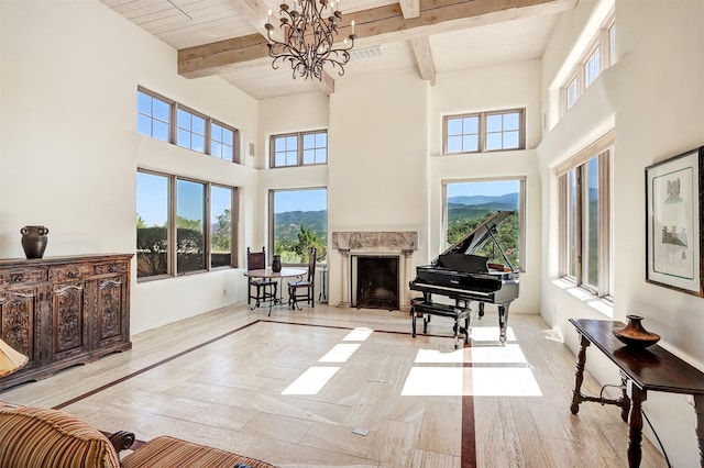 living room with a chandelier, beam ceiling, a healthy amount of sunlight, and a mountain view