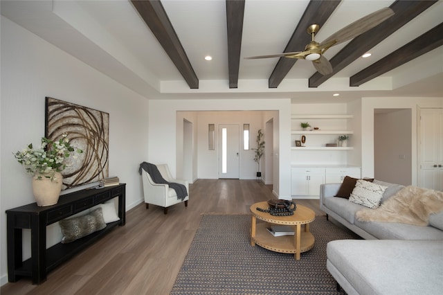 living room with dark hardwood / wood-style floors, beam ceiling, and ceiling fan