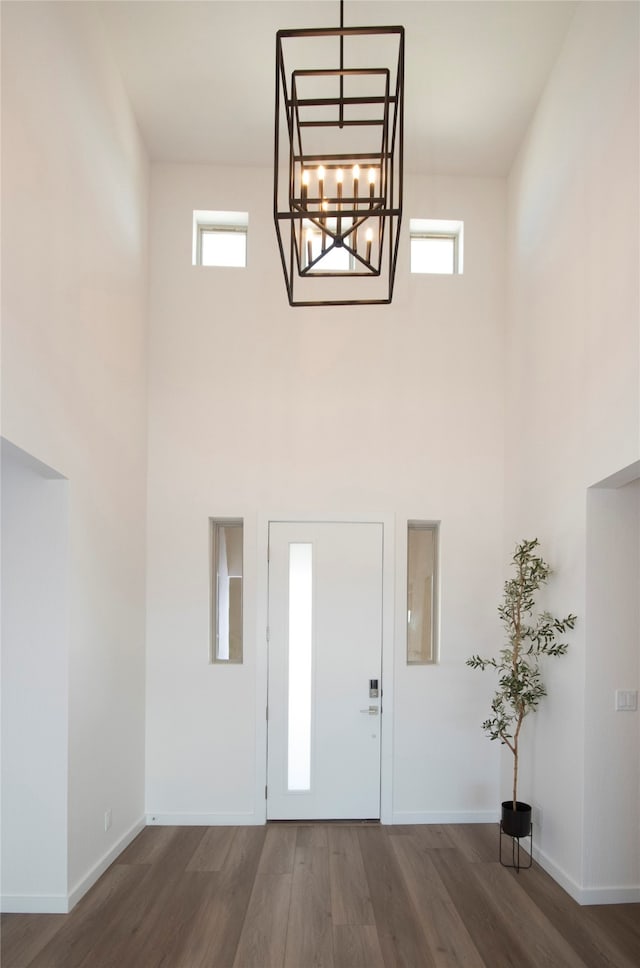 entryway with an inviting chandelier, plenty of natural light, and dark hardwood / wood-style floors