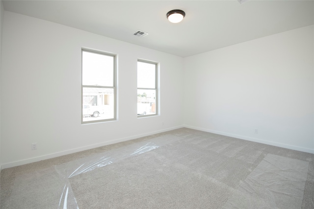 spare room featuring light colored carpet