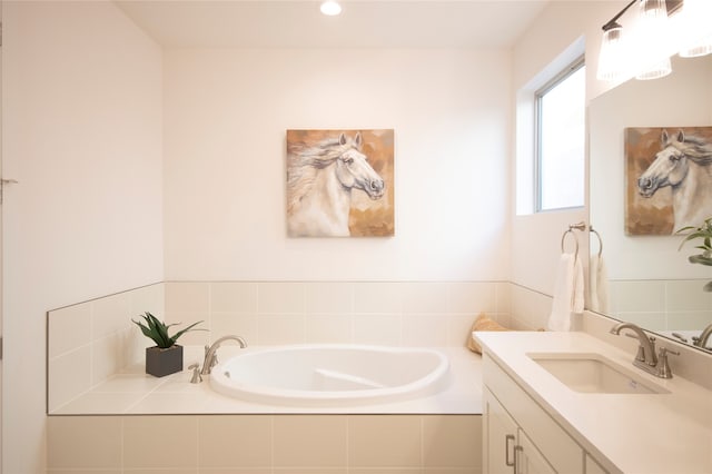 bathroom with tiled bath and vanity