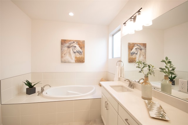 bathroom with vanity and a relaxing tiled bath